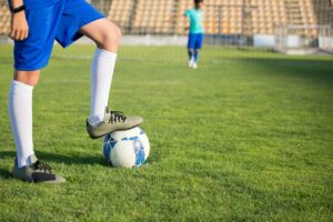 A Person Stepping on the Ball while Wearing Cleats