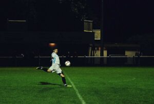 man kicking a soccer ball