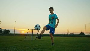 a kid is juggling a soccer ball